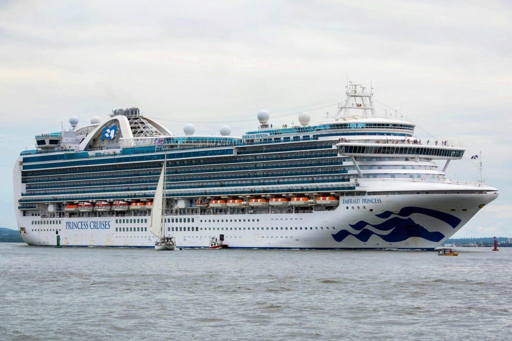 Emerald Princess cruise ship sails through calm waters, showcasing its multi-deck structure and vibrant branding, highlighting luxury travel possibilities.