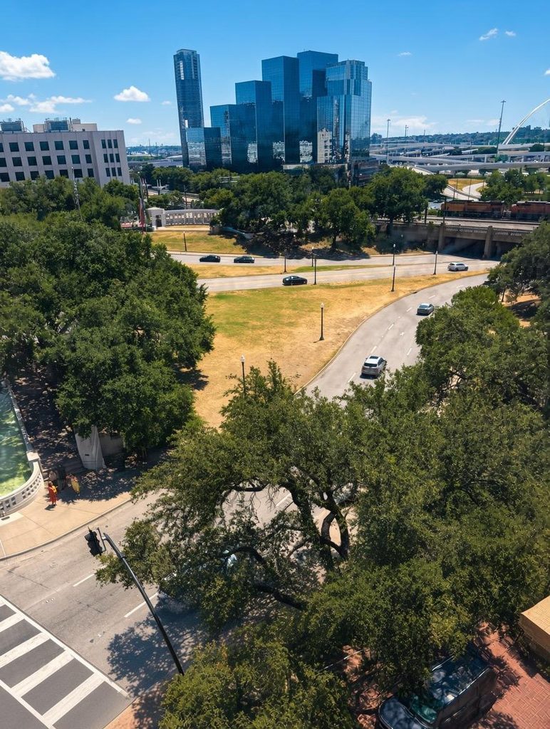 View of the grassy knoll in Dealy Plaza, Dallas. Road with traffic under a clear blue sky