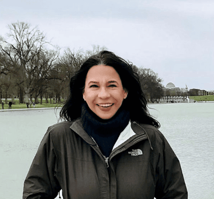 A woman standing in front of a lake